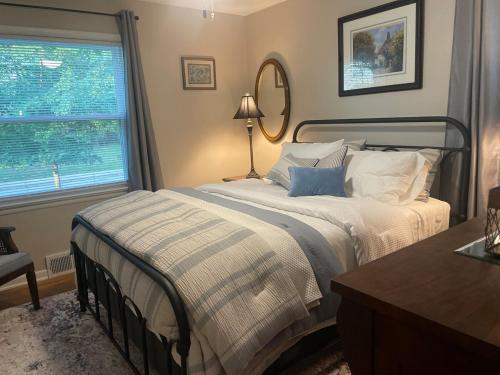 a bedroom with a large bed and a window at Newly renovated 3-bedroom lakeside home in Euclid