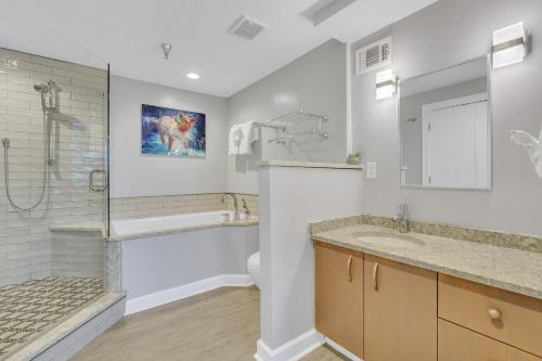 a bathroom with a tub and a sink and a shower at Savannah Skyline in Savannah