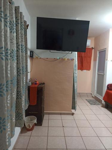 a living room with a flat screen tv above a sliding door at Casa Chero in Comalcalco