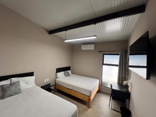 a bedroom with two beds and a window at Urban Beds Expo Guadalajara in Guadalajara