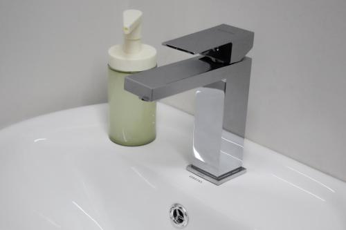 a bathroom with a sink and a faucet at Urban Beds Expo Guadalajara in Guadalajara