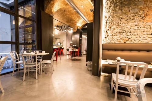 um restaurante com mesas e cadeiras e uma parede de tijolos em Globus Urban Hotel em Florença