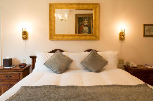 a bedroom with a white bed and a mirror at Wedmore Place in Williamsburg