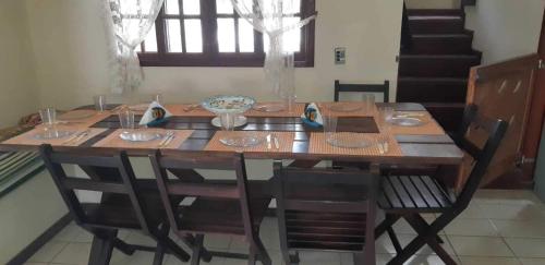 a dining room table with chairs and a wooden table and chairsktop at Casa em Cabo Frio com Piscina e Acesso a Praia in Tamoios