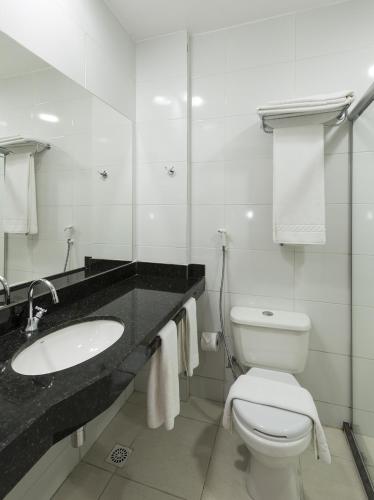 a white bathroom with a sink and a toilet at Arrey Gran Hotel in Teresina