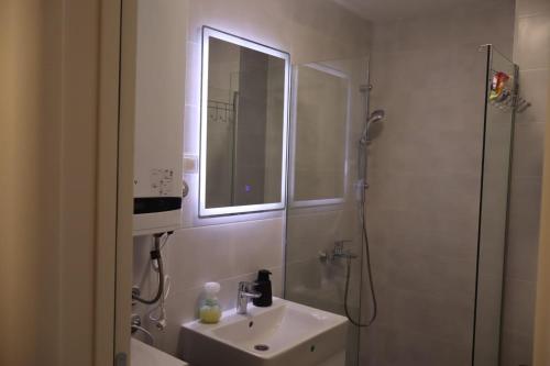 a bathroom with a sink and a shower with a mirror at DivčiNova Luna in Divčibare