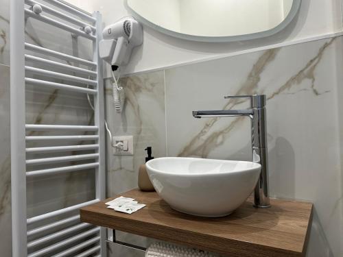 ein Badezimmer mit einem Waschbecken und einem Telefon auf einer Ablage in der Unterkunft La Maison De Milan San Siro in Mailand