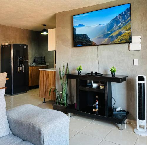 un salon avec une télévision au-dessus d'une cheminée dans l'établissement Depa nuevo cerca del Akron, ITESO, Periferico Sur, à Guadalajara