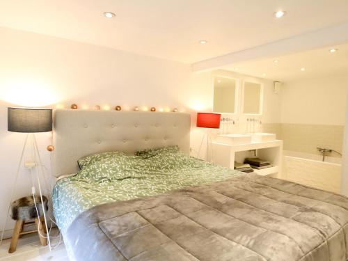 a bedroom with a large bed and a sink at Agathe in Laforêt