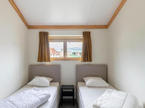 two beds in a room with a window at Westhinder I H19 in Koksijde