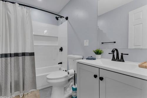 a white bathroom with a toilet and a sink at The Boho Lux Haven Prov in Providence