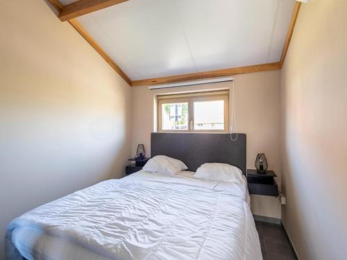 a bedroom with a large bed with a window at Westhinder I H21 in Koksijde