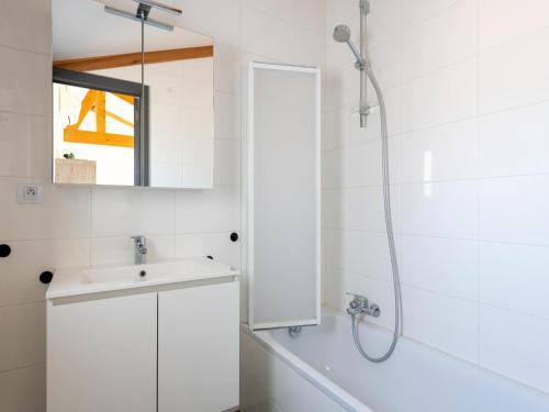 a white bathroom with a shower and a sink at Westhinder I H21 in Koksijde
