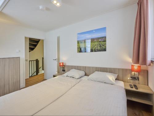 ColijnsplaatにあるBeach deluxeの大きな白いベッドと2つのランプのある寝室