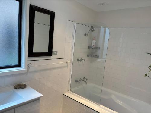 a bathroom with a shower with a glass door at Gravity Stayz in Batehaven