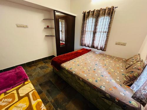 een kleine slaapkamer met een bed en een raam bij Coastal Nest Home - Malpe Beach in Malpe