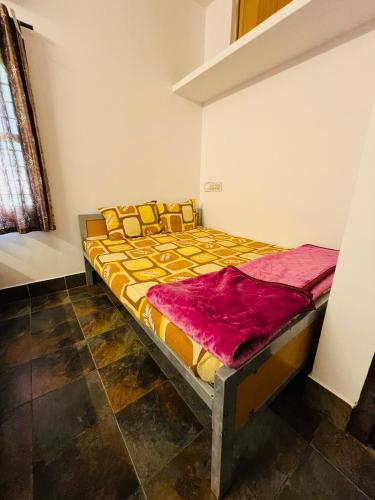 a bedroom with a bed with a yellow and orange comforter at Coastal Nest Home - Malpe Beach in Malpe