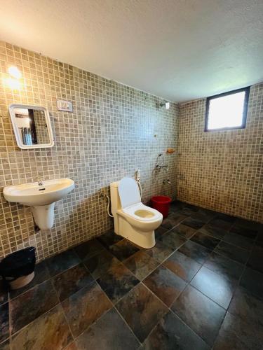 a bathroom with a toilet and a sink at Coastal Nest Home - Malpe Beach in Malpe