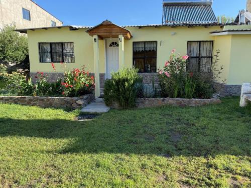 a yellow house with a porch and flowers at Casa Elia in Creel