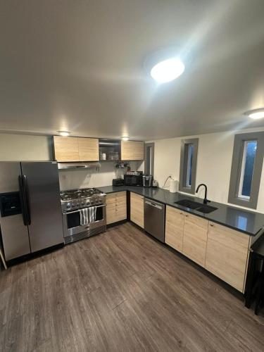 a kitchen with stainless steel appliances and wooden cabinets at Hidden Oasis in Victoria, BC in Victoria
