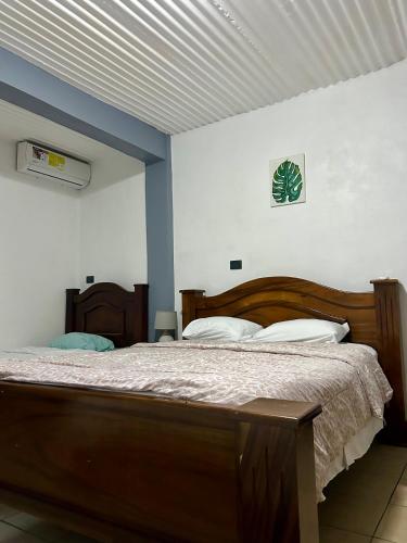 a bedroom with a wooden bed in a room at Hotel & Restaurante Tabacones in Guácimo