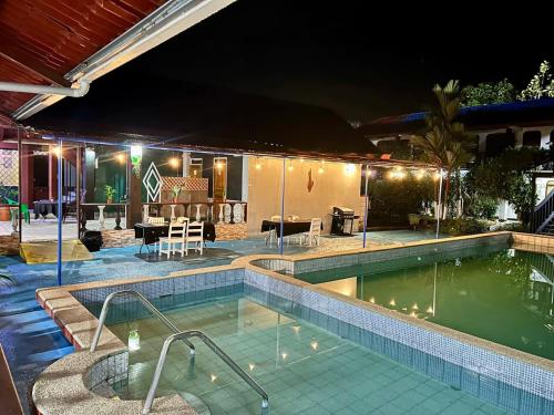 a swimming pool at night with a house at Hotel & Restaurante Tabacones in Guácimo