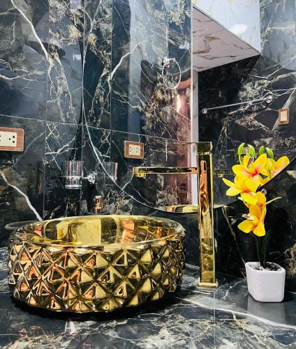 a bathroom with a gold tub on a counter with flowers at Aristobilo Aloft- Matrimonial 2 in Chachapoyas