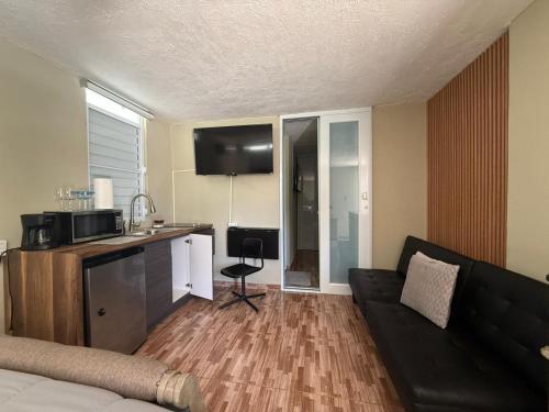 Una sala de estar con un sofá y una cocina. en Colombiano boricua, en Quebradillas