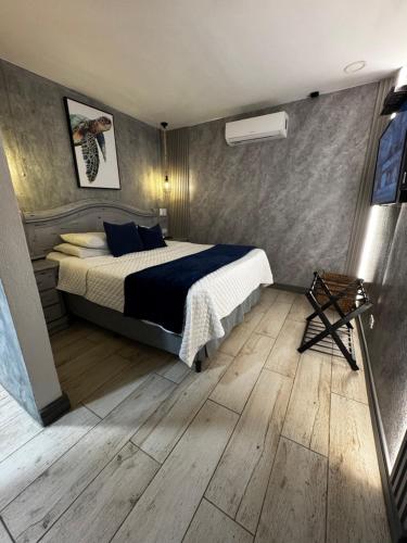 a bedroom with a bed and a wooden floor at Berlor Airport Inn in Alajuela City