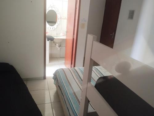 une chambre avec un lit et une salle de bains avec un miroir dans l'établissement Elaine, à Cachoeira Paulista