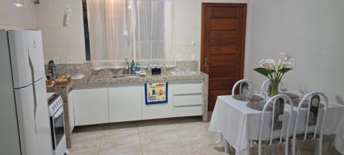 a kitchen with a sink and a refrigerator and a table at Casa Bello Monte in Venda Nova do Imigrante