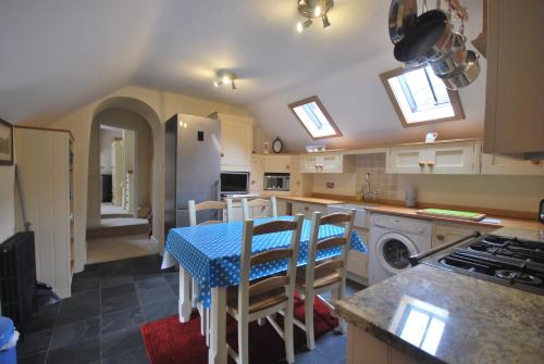 uma cozinha com uma mesa com uma toalha de mesa azul em Apartment Finchale Abbey em Durham