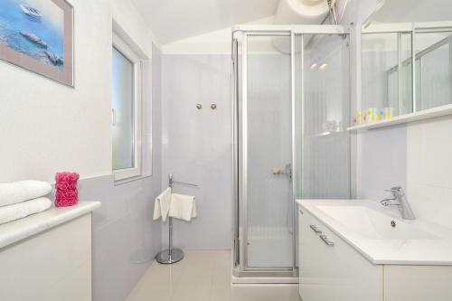希杰弗朗吉卡Seaside apartments with a swimming pool Seget Vranjica, Trogir - 4284的带淋浴和水槽的白色浴室