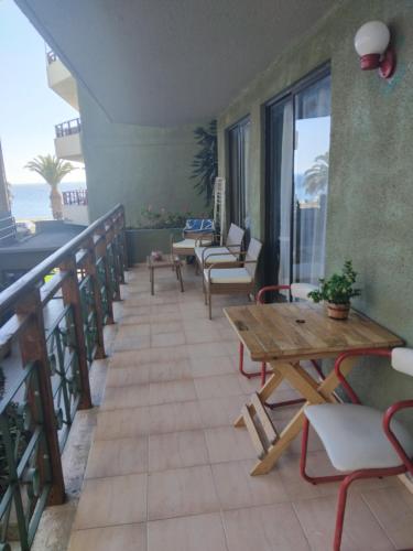 uma varanda com mesa e cadeiras e vista para o oceano em Lindo depa en la playa chica em Papudo