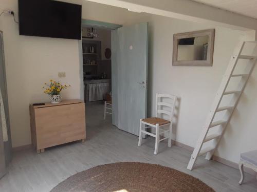 a living room with a tv and a desk and ladder at Sognare sul mare in Granelli