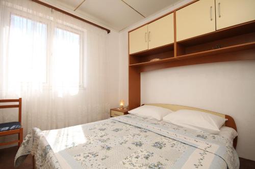 a bedroom with a bed and a window at Holiday house with a parking space Lukoran, Ugljan - 8385 in Lukoran