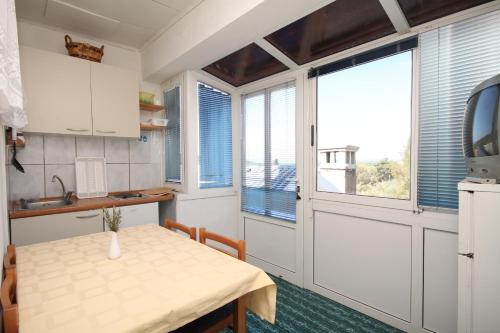 a kitchen with a table and a window at Holiday house with a parking space Lukoran, Ugljan - 8385 in Lukoran