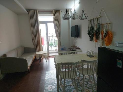 a living room with a table and chairs and a couch at DINO Home HACOM 2BR city center in Kinh Dinh