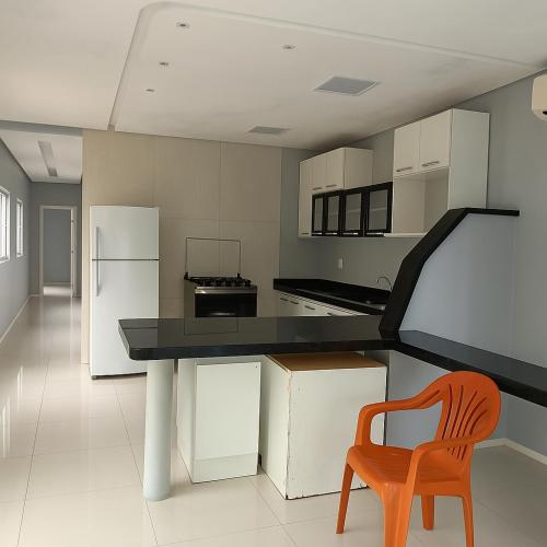 une cuisine avec une table et une chaise orange dans l'établissement AP disponível para aluguel, à Belém