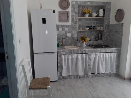a kitchen with a white refrigerator and a stove at Sognare sul mare in Granelli