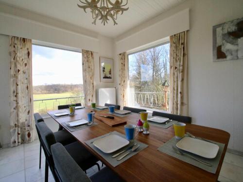 a dining room with a table and a large window at Le Beau Souvenir, Noiseux in Noiseux