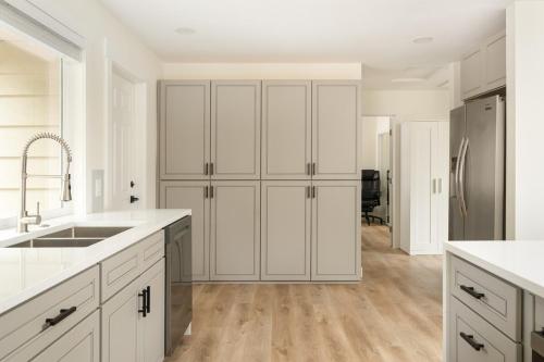 una cucina con mobili bianchi e un lavandino di Modern Nest - Cozy & Free Parking a Edgewood