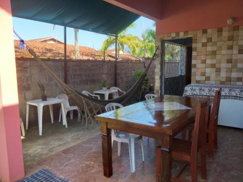 a patio with a hammock and a table and chairs at Casa Temporada Bertioga- Indáia in Bertioga