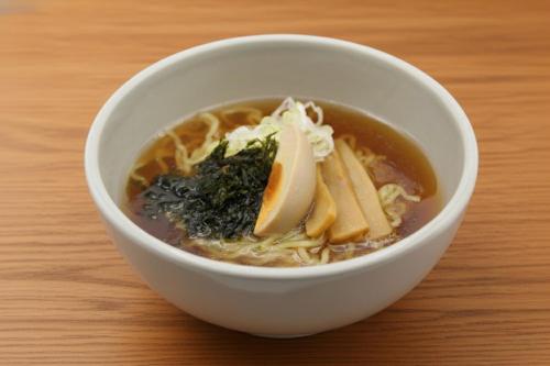 a white bowl of soup with noodles and lemon slices at Dormy Inn Matsumoto in Matsumoto