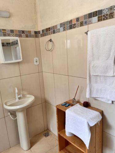 um pequeno banheiro com uma pia e um vaso sanitário em Hostel da Dri em Aiuruoca