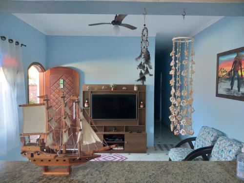 a living room with a flat screen tv and a couch at Casa Temporada Bertioga- Indáia in Bertioga