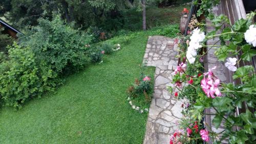 a garden with flowers and a stone wall at Holiday Home Tirol in Vlasic