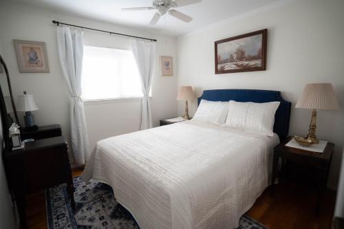 una camera da letto con un letto bianco e una finestra di Charming Getaway Make Memories a Sterling Heights
