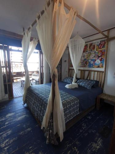 a bedroom with a canopy bed with mosquito nets at Máncora Beach apartment in Máncora