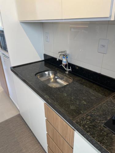a kitchen with a sink and a counter top at Flat Executivo, Moderno e Aconchegante - Ahava Stays in Montes Claros